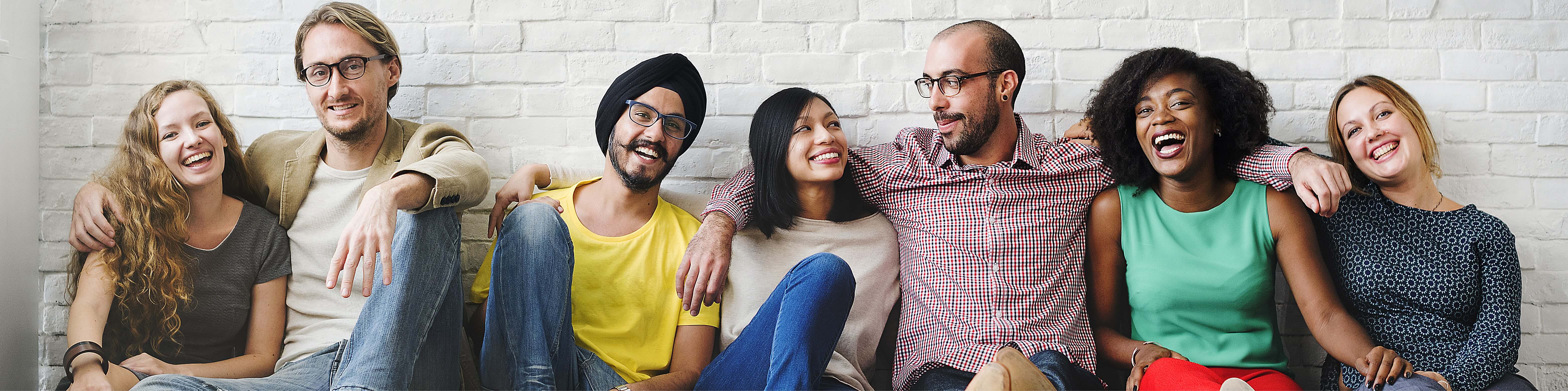 group of people sitting with a white wall on background